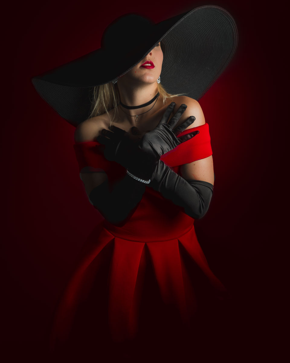 A woman in a red dress with a black hat.