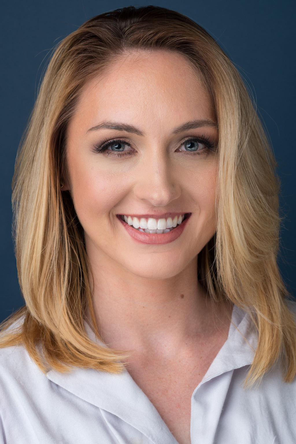 A smiling woman in a white shirt.