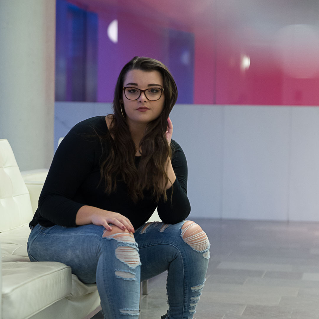 A woman sitting on a white couch.