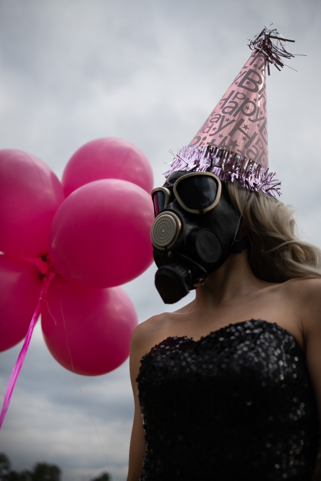 A woman celebrating her pandemic birthday with pink balloons and a gas mask.
Keywords used: Pandemic Birthday, pink balloons, gas mask.