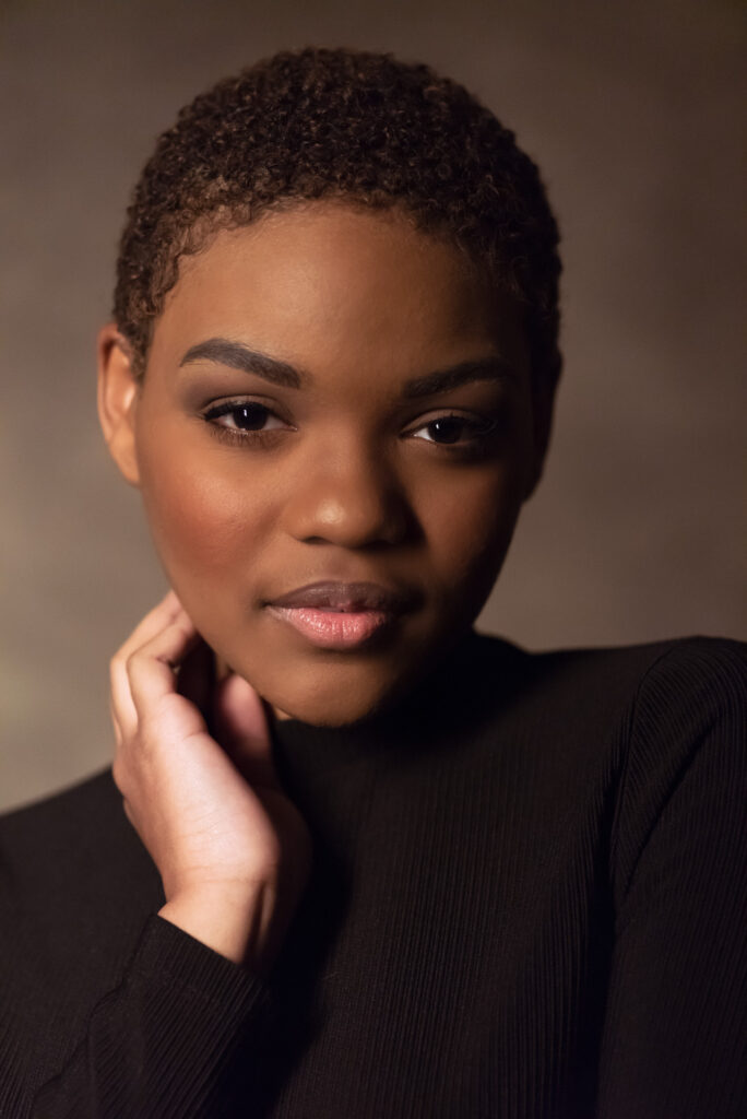 A black woman with short hair posing for headshots in 2022.