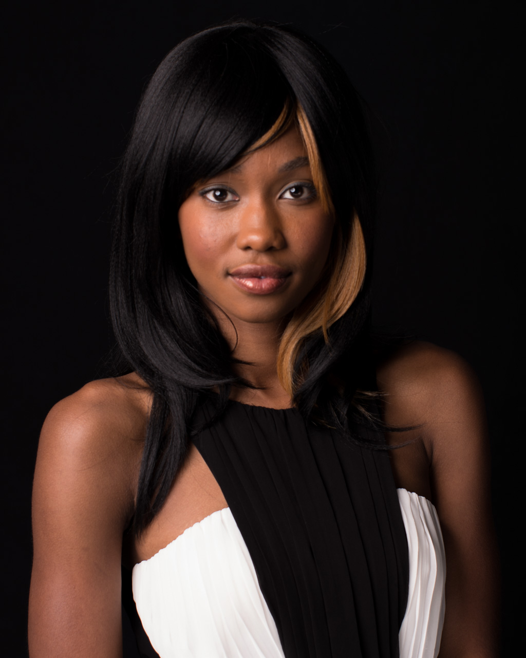 A black woman in a dress posing for headshots in 2022.