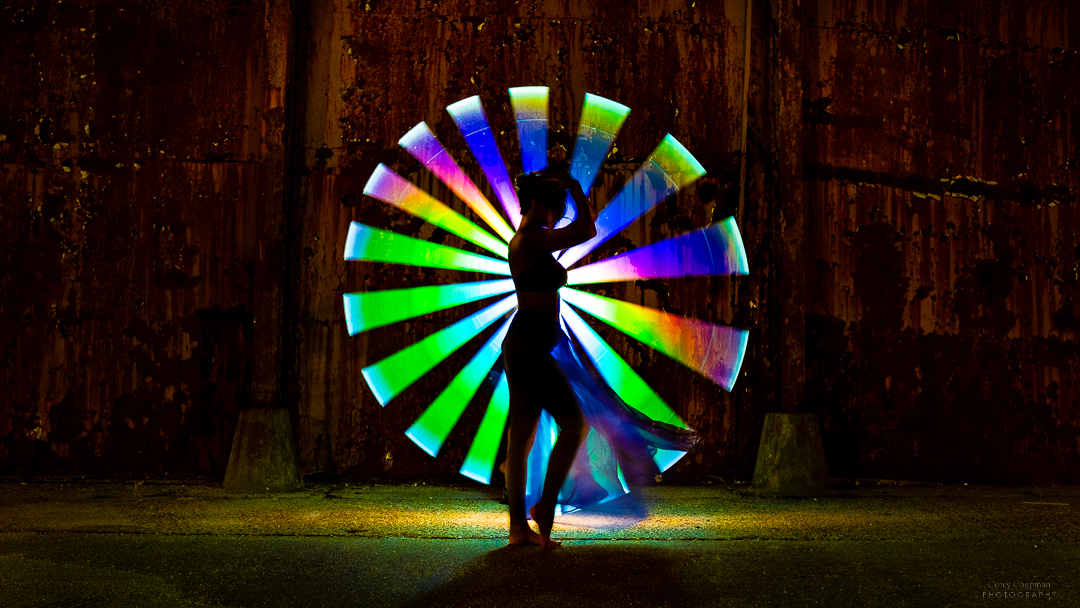 A woman is standing in front of a spinning auto wheel.