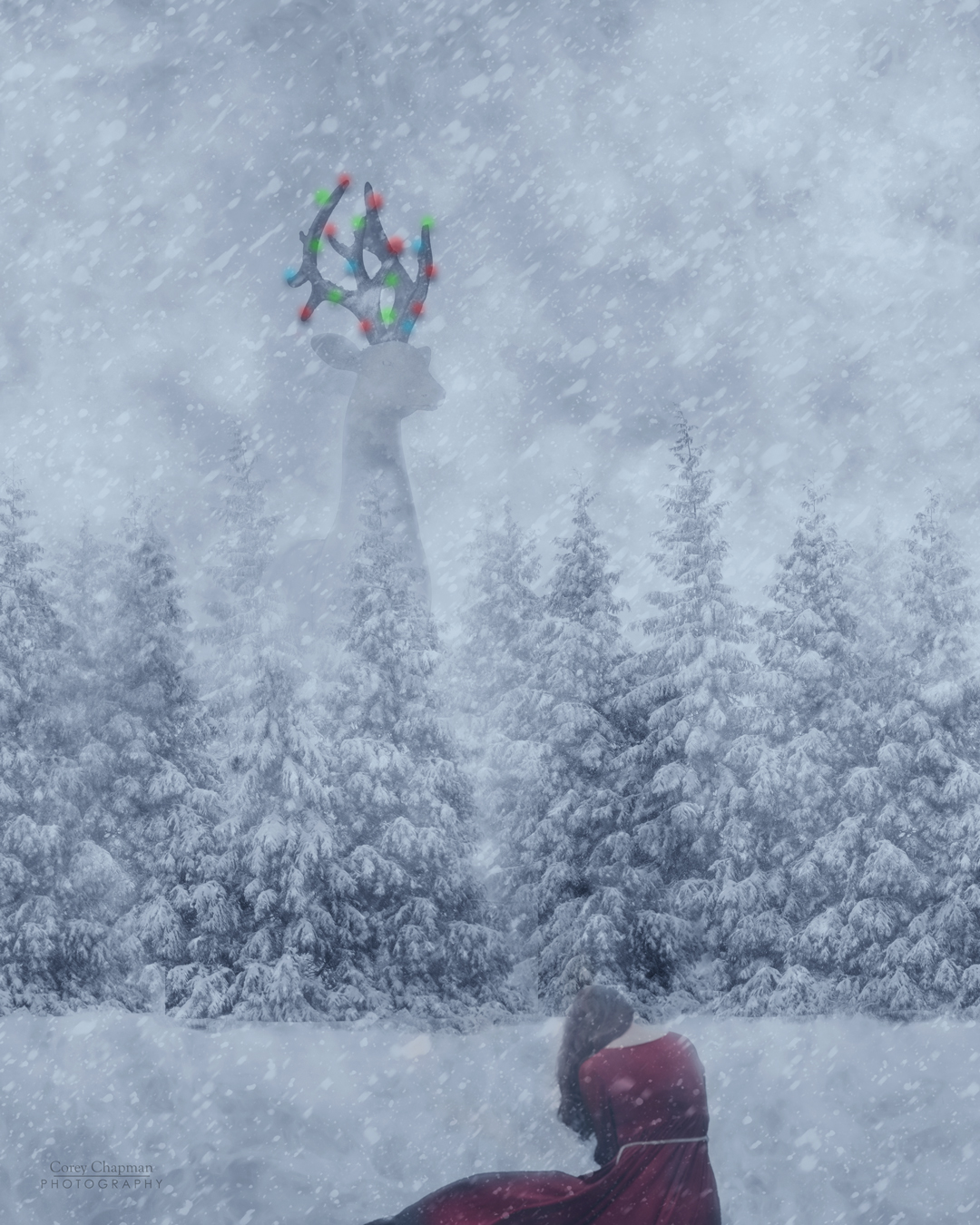 A single girl in a red cloak kneels in a snowy forest, evoking the magic of Christmas, as large, colorful antlers emerge from a distant figure.